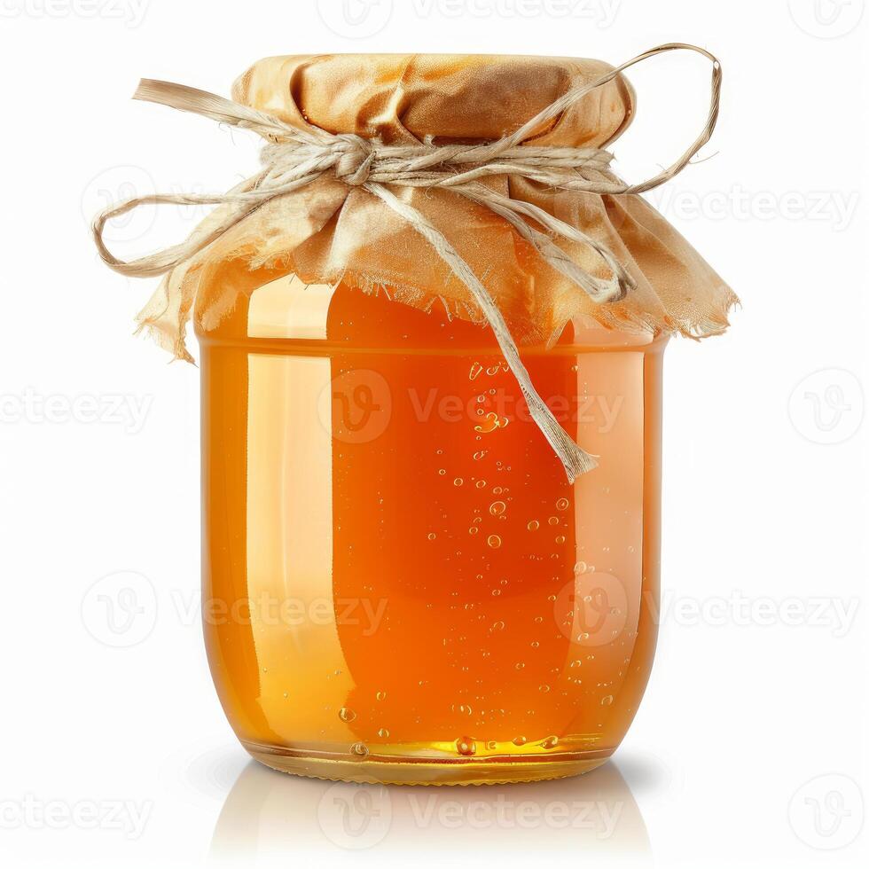 Glass jar of golden honey covered with brown paper and tied with string photo