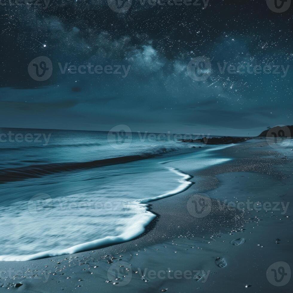 Milky way over calm ocean waves crashing on sandy beach at night photo