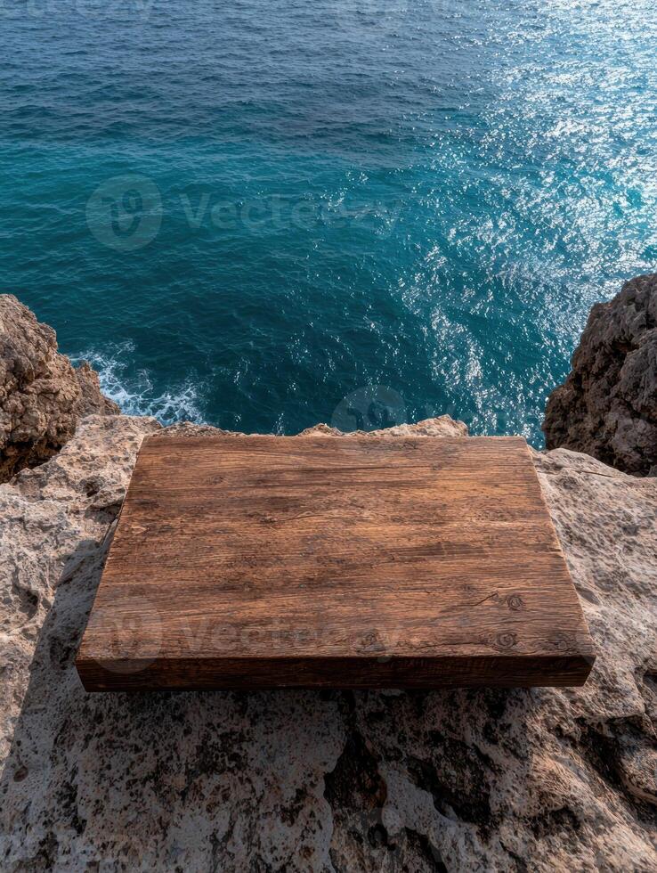 Dark brown wooden board on rocky cliff overlooking ocean photo