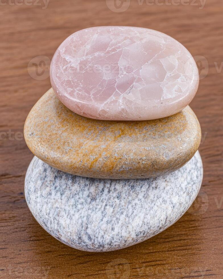 Stack of three stones on wooden surface photo