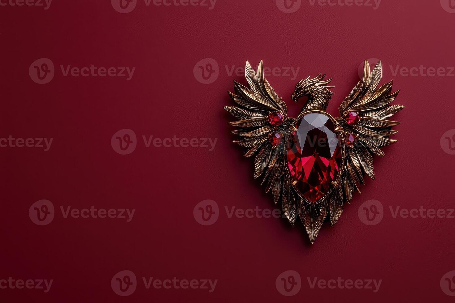 Ornate ruby and gold phoenix brooch on red background photo