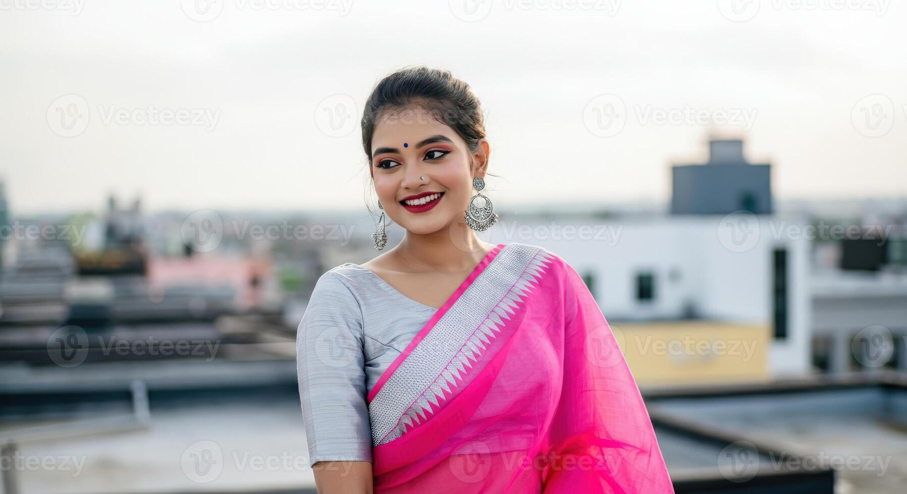 Vibrant young south asian woman in traditional pink saree smiling outdoors photo
