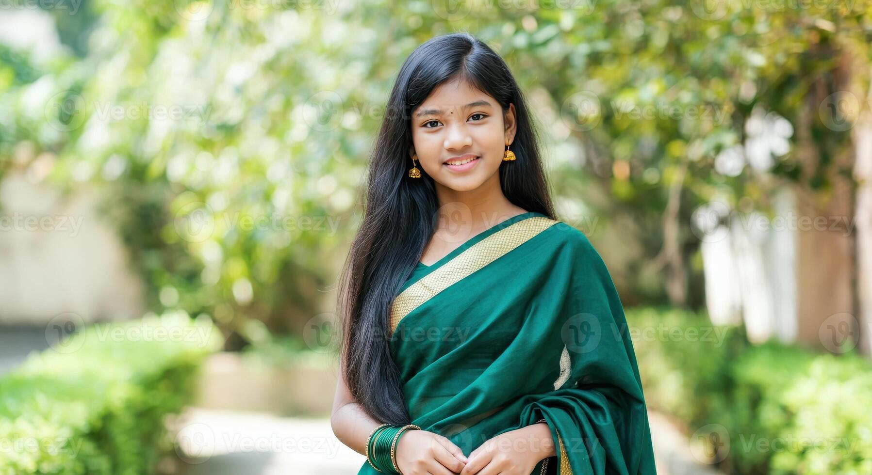 Young asian female in traditional green sari outdoors amidst lush garden setting photo