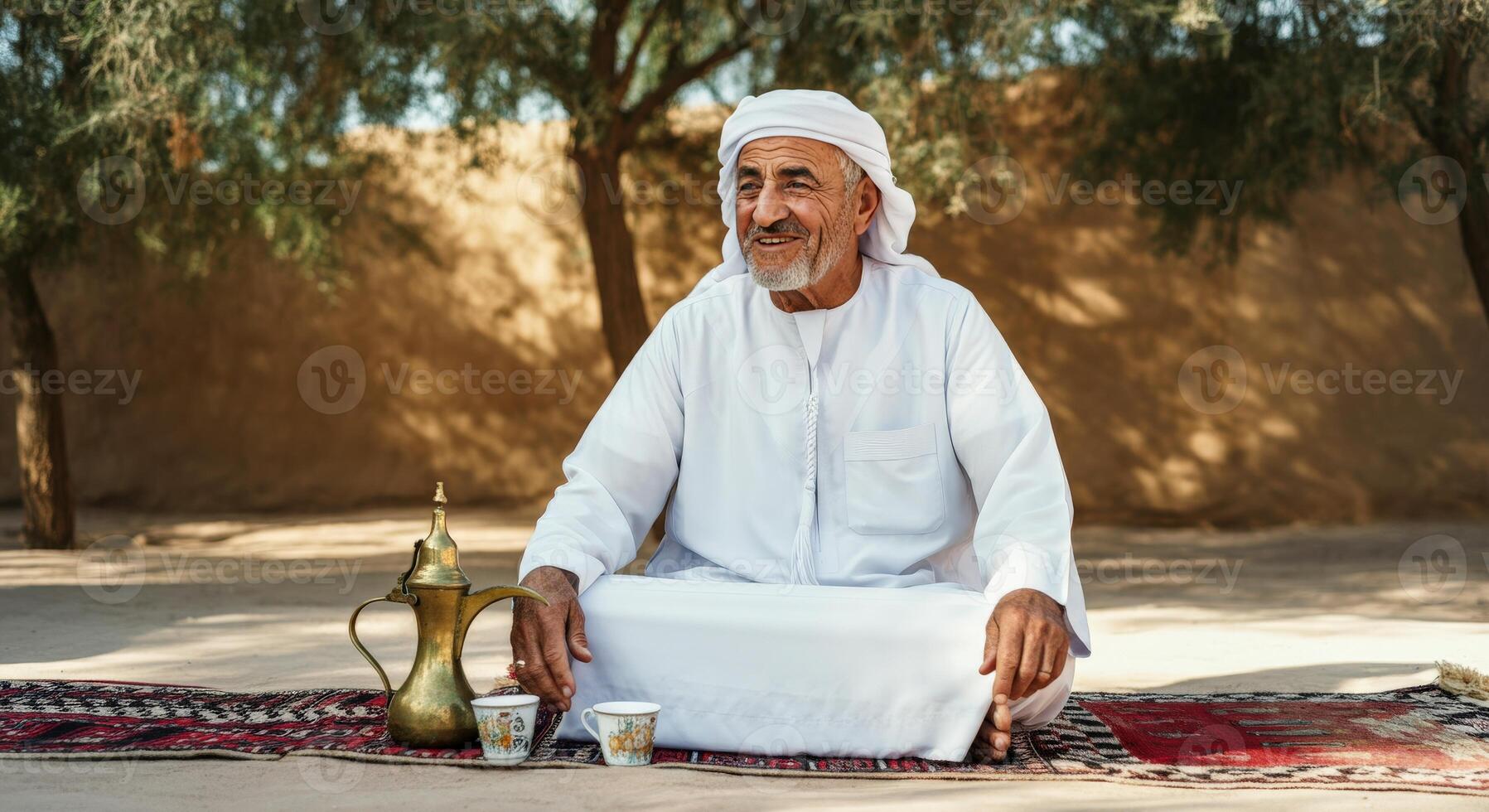 Elderly middle eastern man enjoying tea in traditional desert setting for cultural appreciation photo