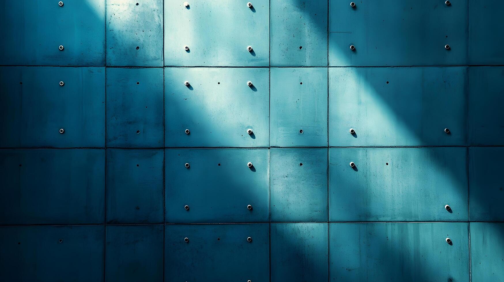 Industrial concrete wall with dramatic downlighting and blue-tinted surface, featuring geometric panel patterns and metallic rivets in modern brutalist architectural style. modern photo