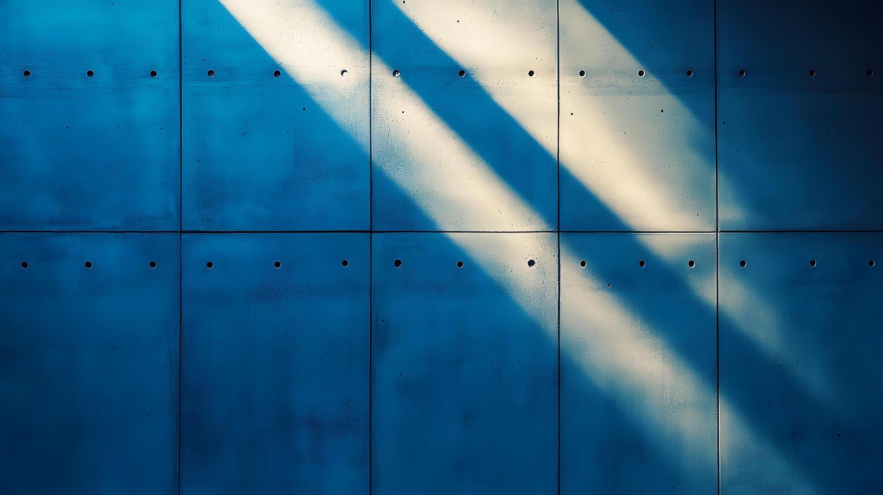 Industrial concrete wall with dramatic downlighting and blue-tinted surface, featuring geometric panel patterns and metallic rivets in modern brutalist architectural style. composition photo