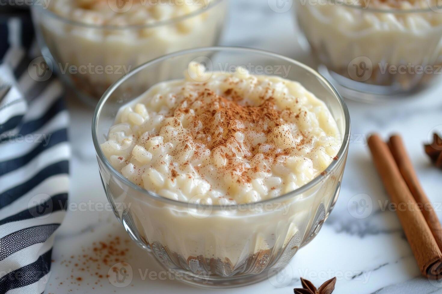 Creamy rice pudding garnished with cinnamon in glass bowls photo