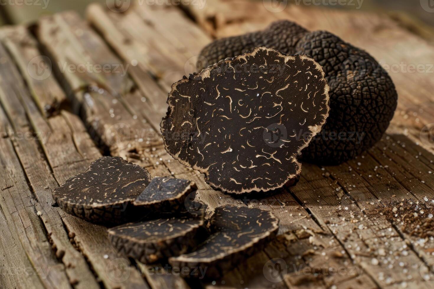 Fresh black truffles showing cross section on rustic wooden table photo