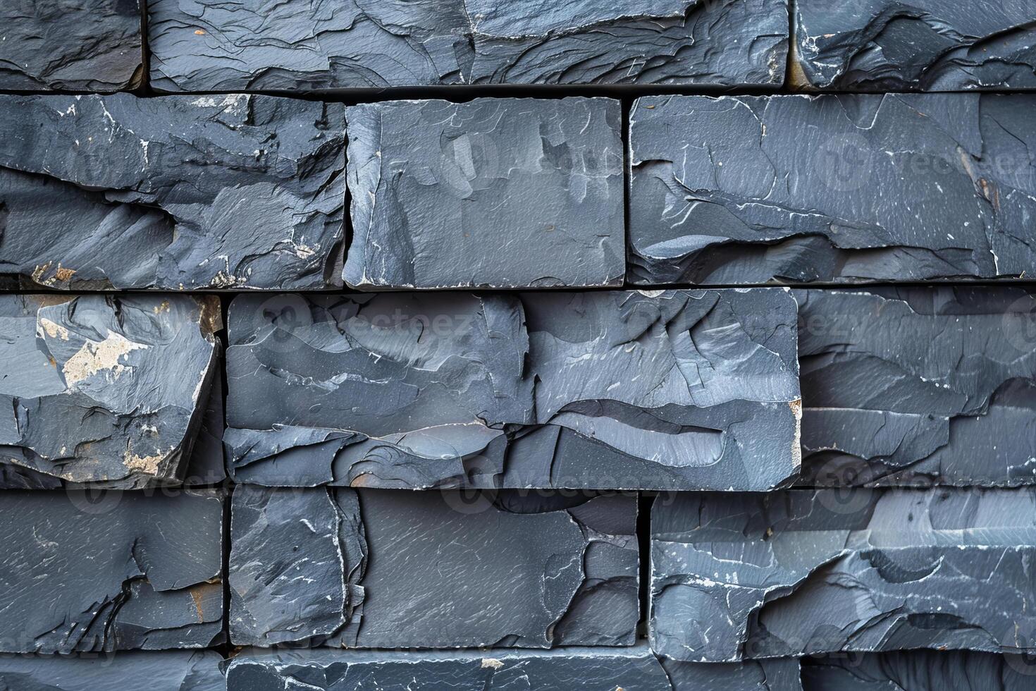 Dark grey stone wall cladding forming textured background photo