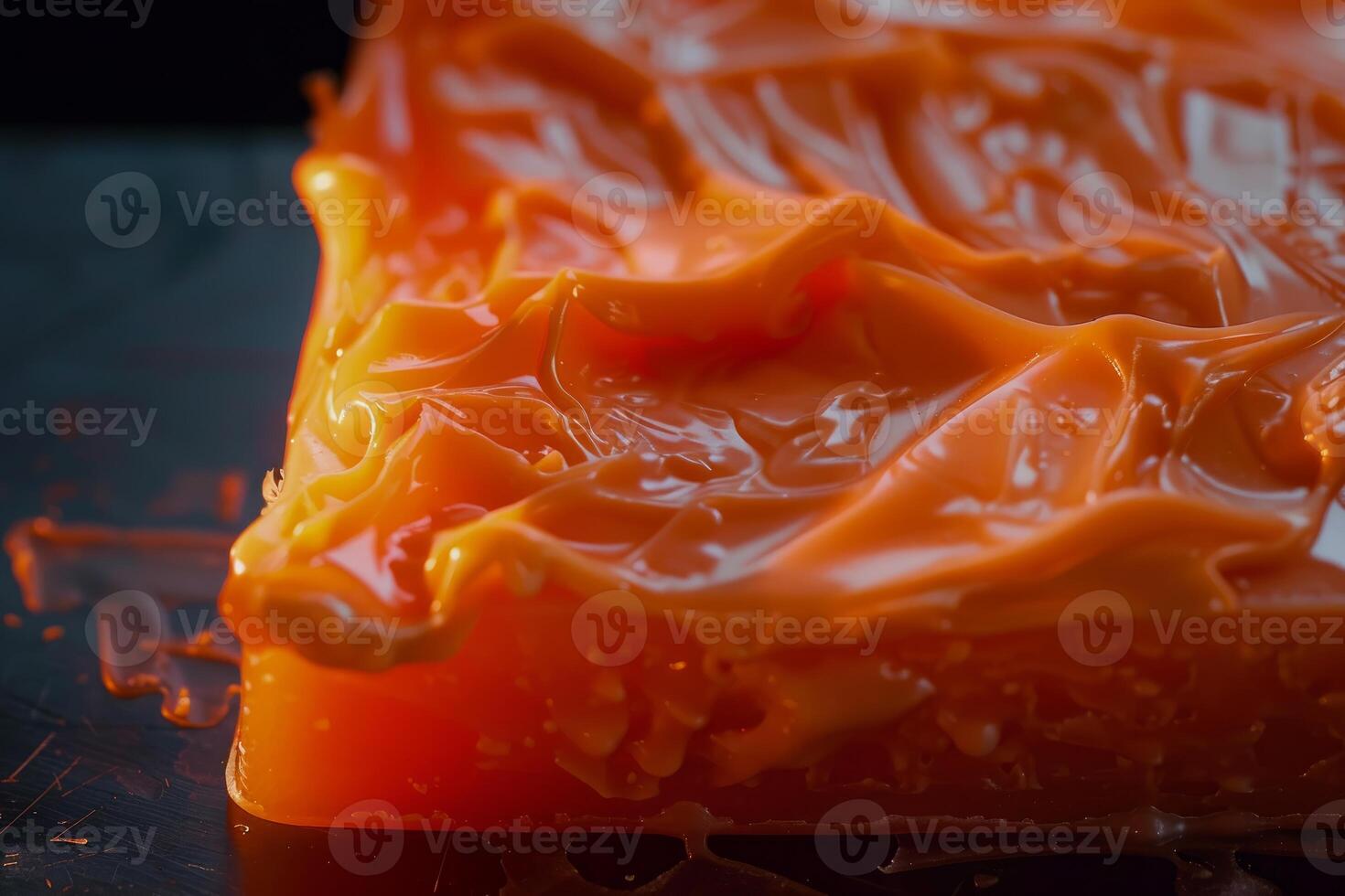 Orange grease melting on hot surface, industrial lubricant detail photo