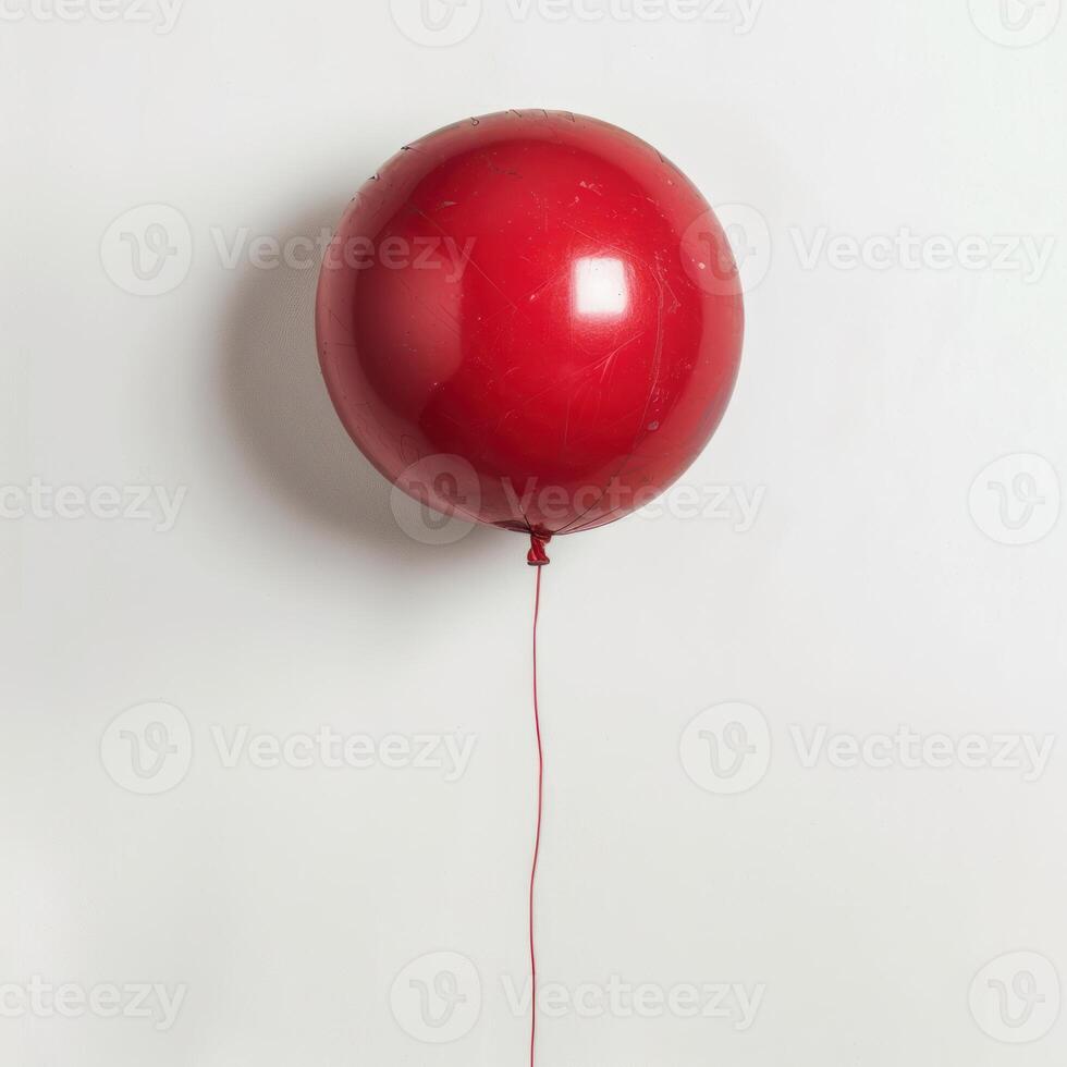 Red balloon floating on white background representing simplicity and minimalism photo