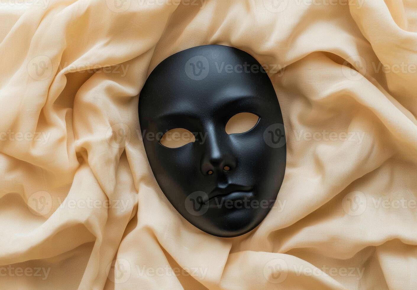 Black theatrical mask on beige fabric photo