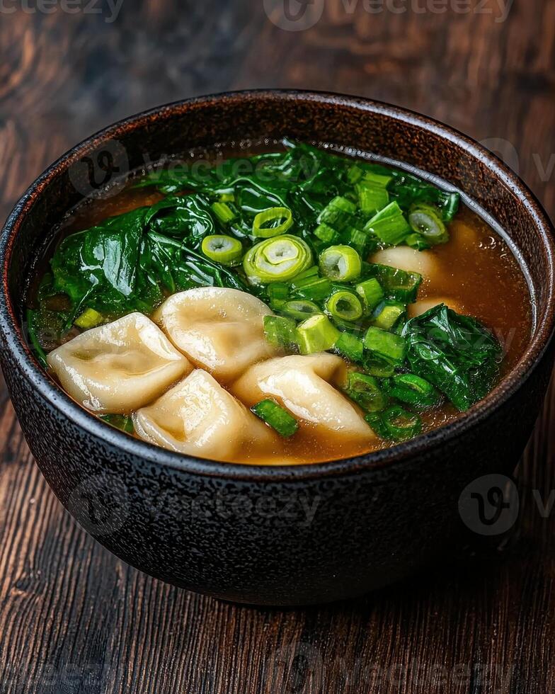 Delicious dumplings in a savory broth with spinach and green onions photo