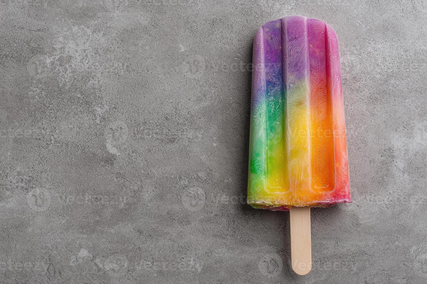 Rainbow popsicle on gray background photo
