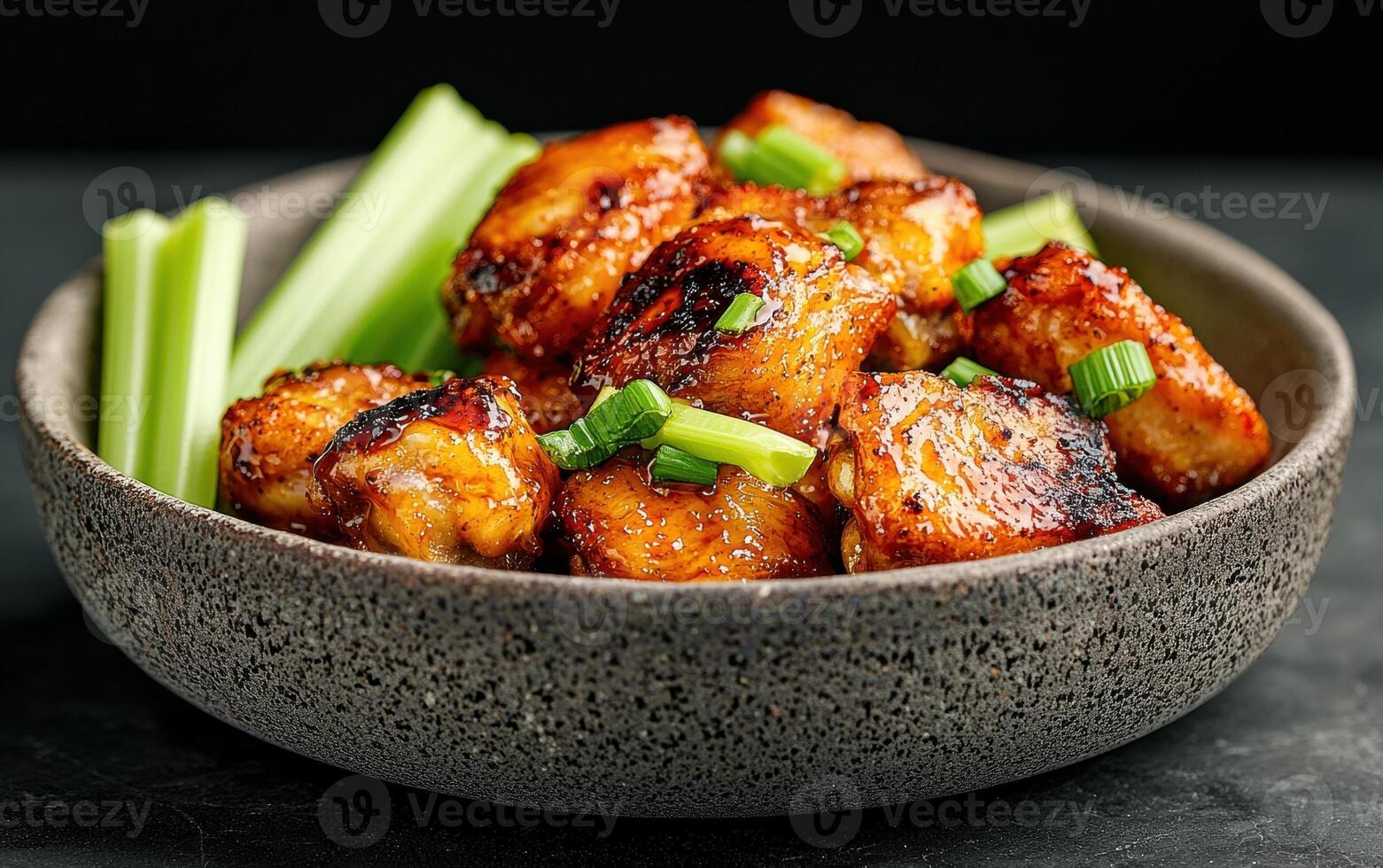 Close up of delicious glazed chicken pieces with celery sticks photo