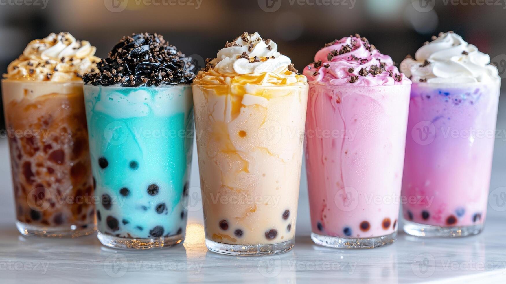 Five colorful bubble tea drinks with whipped cream and toppings. photo