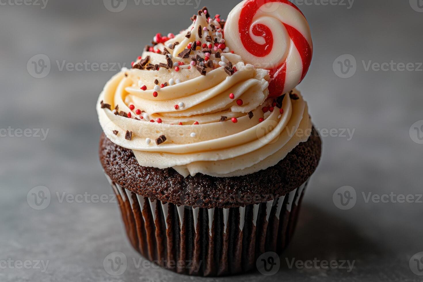 Close up of a chocolate cupcake with vanilla frosting and candy cane photo