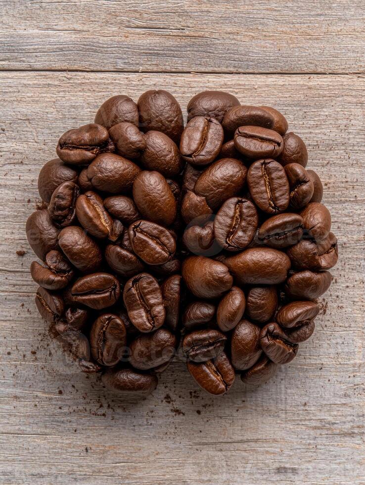 Roasted coffee beans arranged in the shape of a brain on a wooden surface photo