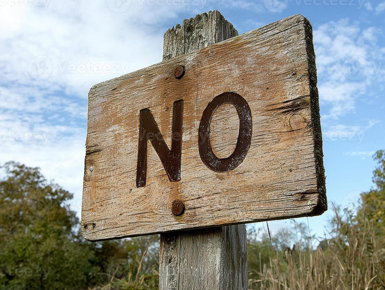 Close up of a weathered wooden sign with the word NO photo