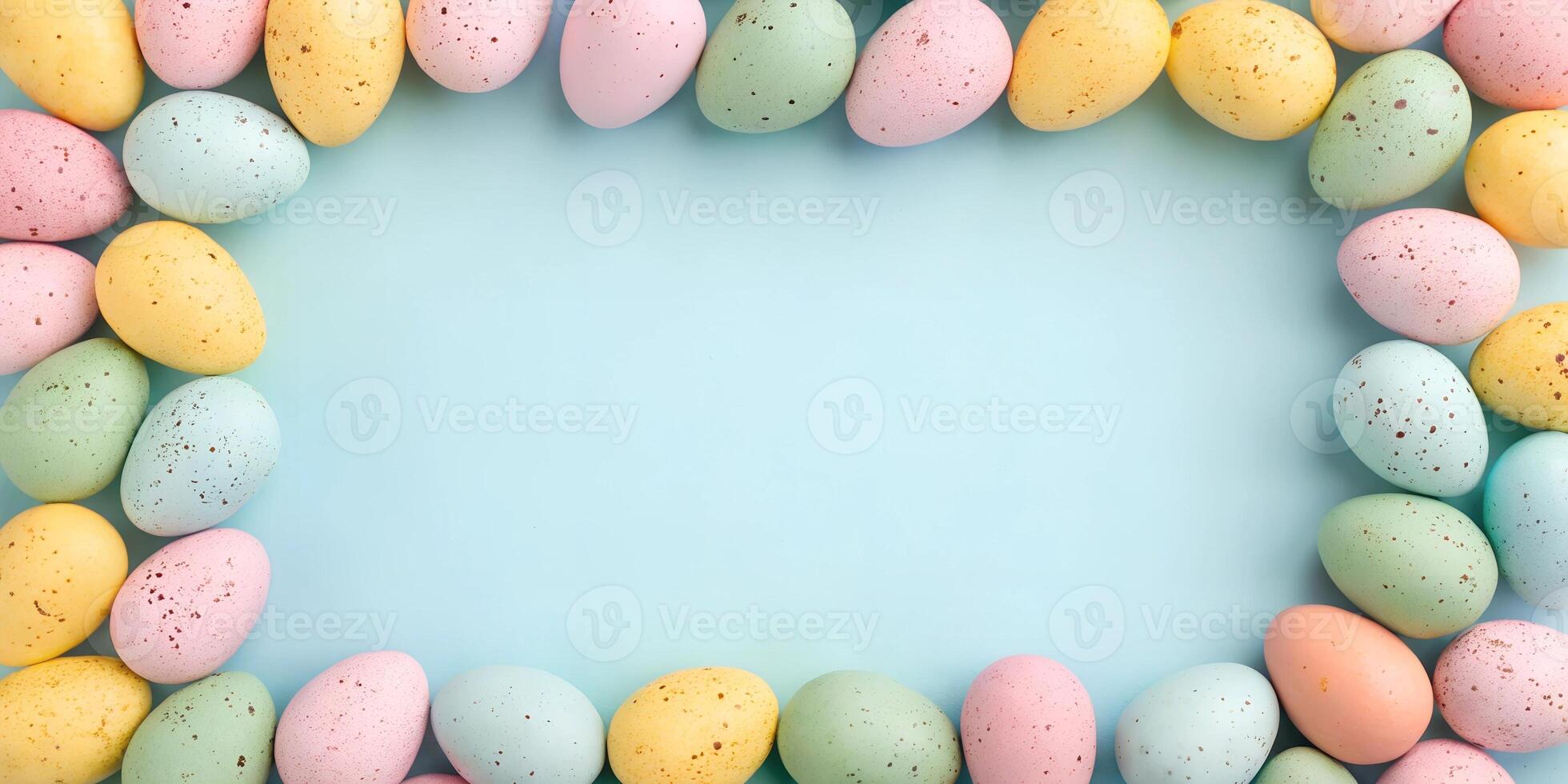 Flat lay composition of pastel Easter eggs forming a frame on a blue background. Holiday mockup with copy space photo