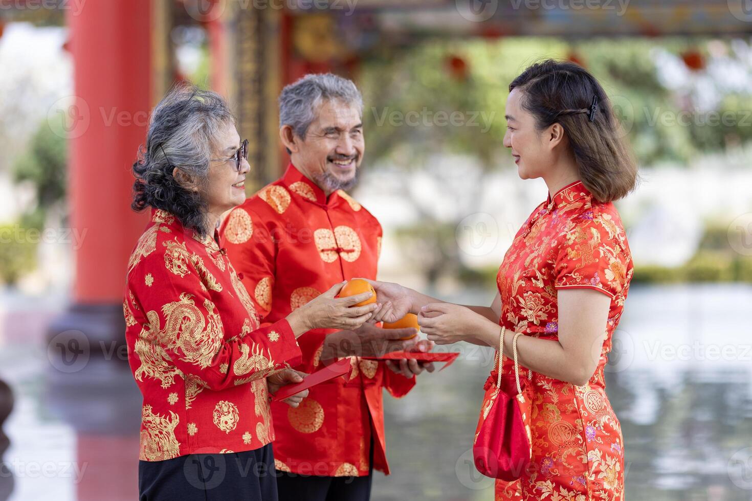 Asian family with senior parent in red cheongsam qipao dress is offering food to ancestral god at Chinese Buddhist temple during lunar new year for best wish blessing and good luck photo