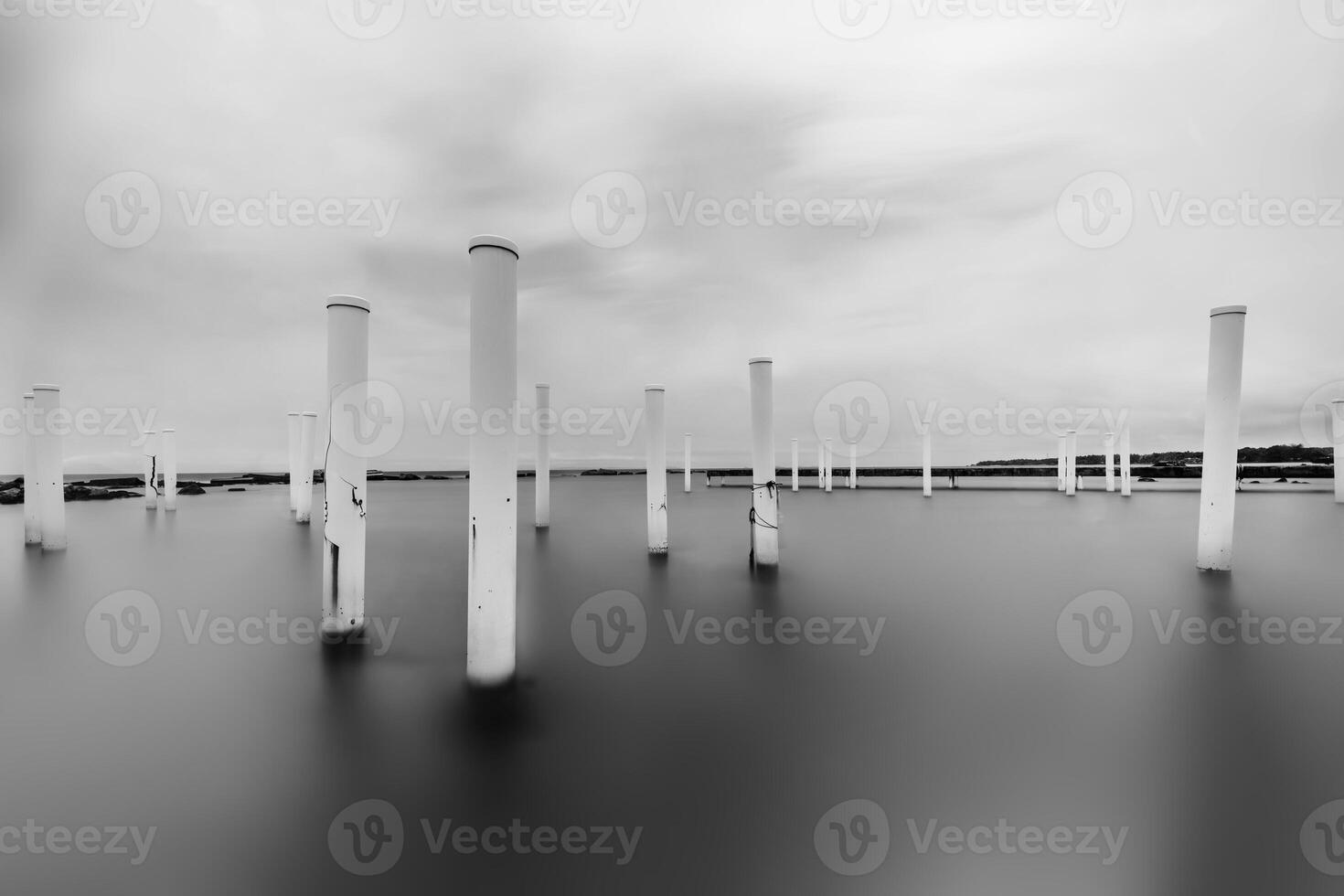 Upright. Pillars in the water in black and white. Minimalist fine art concept. photo