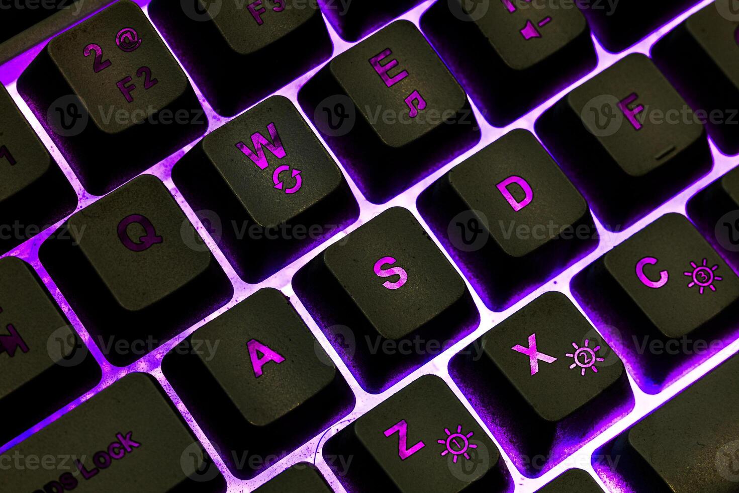 Black keyboard with purple light ambience. WASD keyboard keys photo