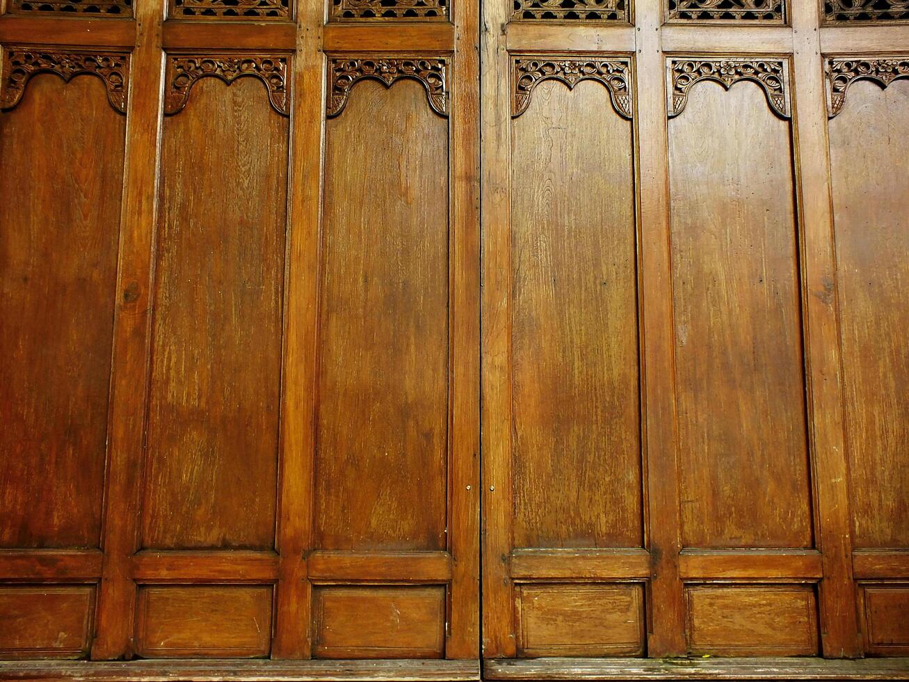 Javanese traditional wooden paneling has a rustic and old fashioned look to it. The wood grain is visible and the paneling is slightly worn, giving the room a cozy feel photo