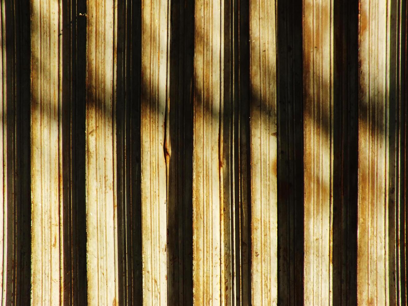 Abstract background texture of a wooden surface with a pattern of stripes. The stripes are faded and the surface appears to be old and worn. Scene is somewhat somber and nostalgic photo