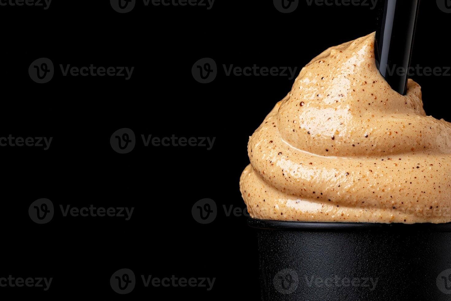 Close up of a delicious creamy dessert with coffee topping in a black cup photo