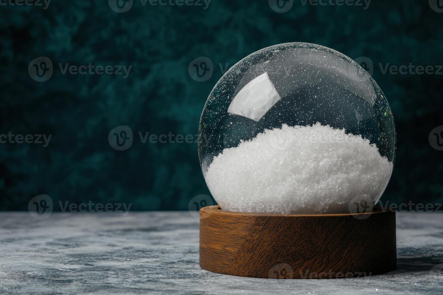 Snow globe with wooden base on a teal background photo