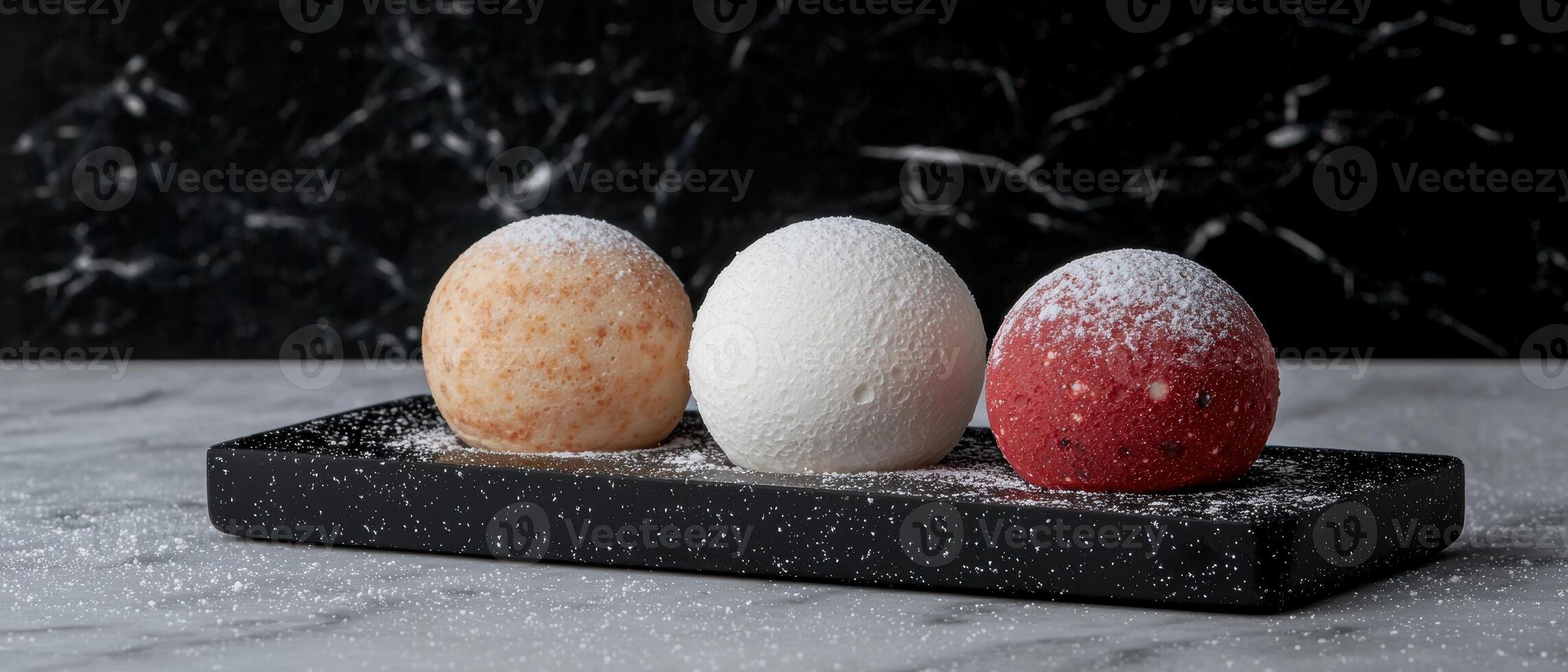 Three colorful dessert spheres on a black tray photo