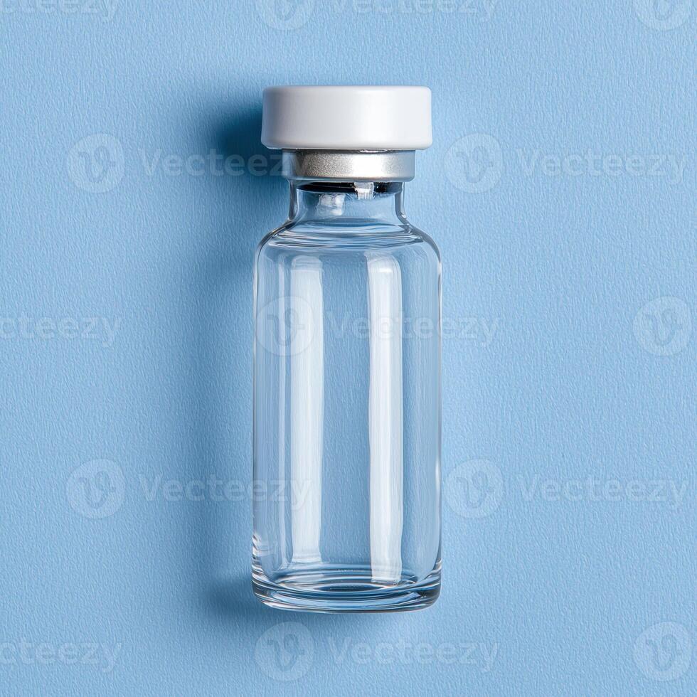 Empty glass vial with white cap on blue background photo