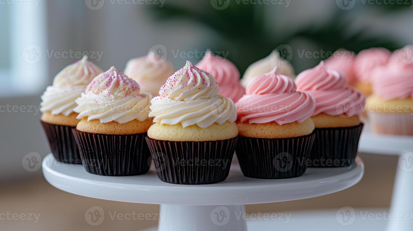 Delicious cupcakes with pink and white frosting on a white cake stand. photo