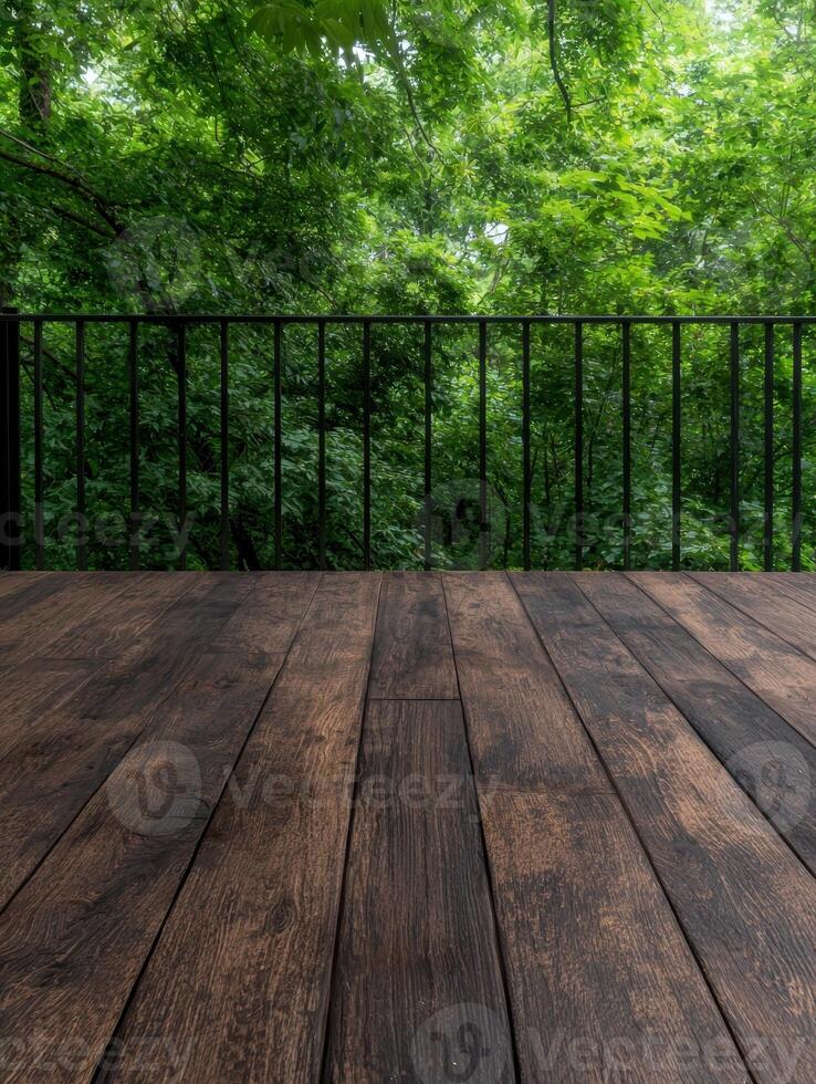 Dark brown wooden deck overlooking lush green forest photo