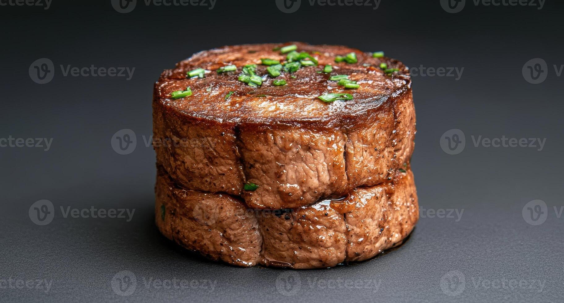 Close up of two stacked beef medallions, seasoned and grilled to perfection photo