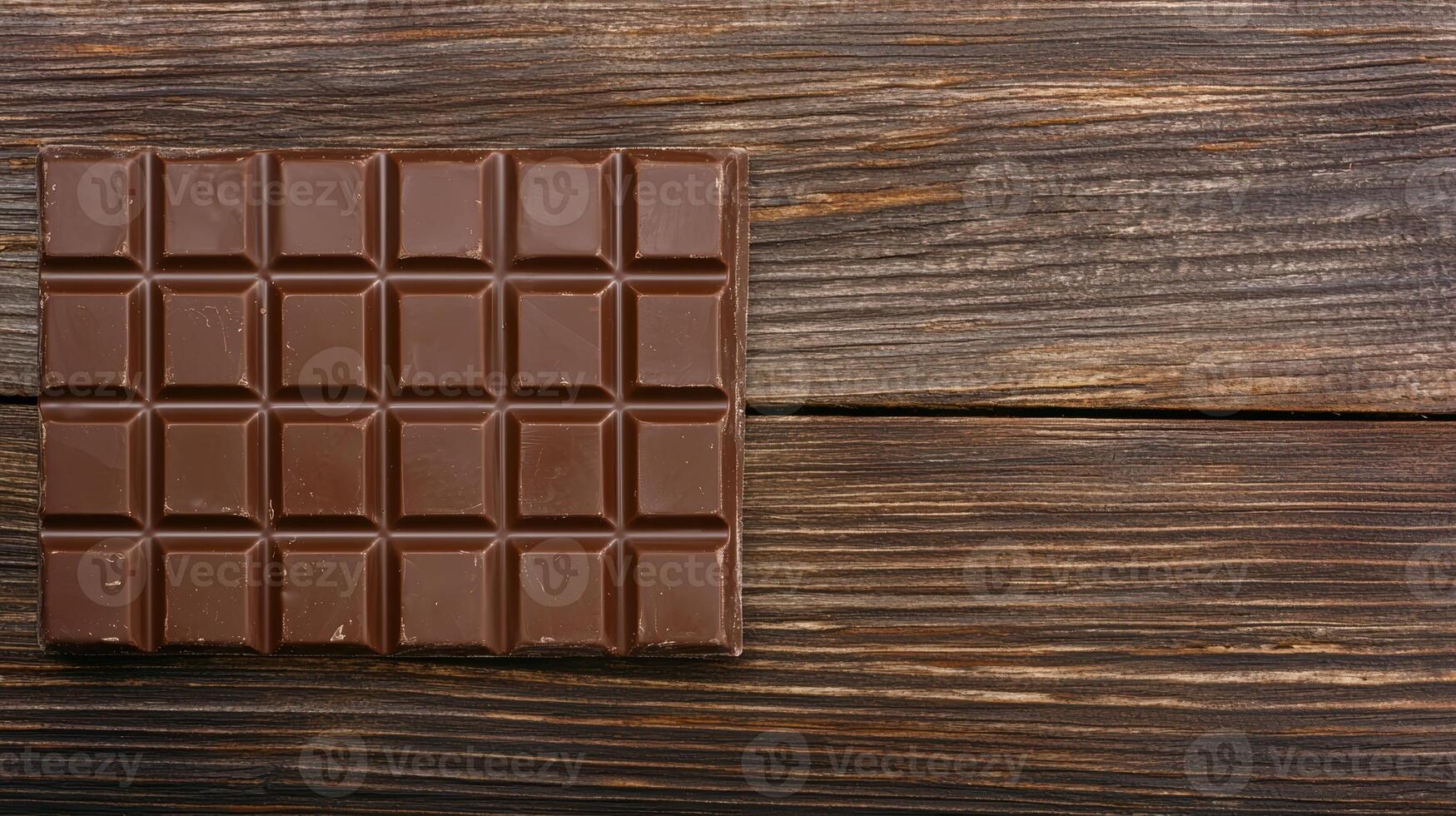 Dark chocolate bar on wooden table photo