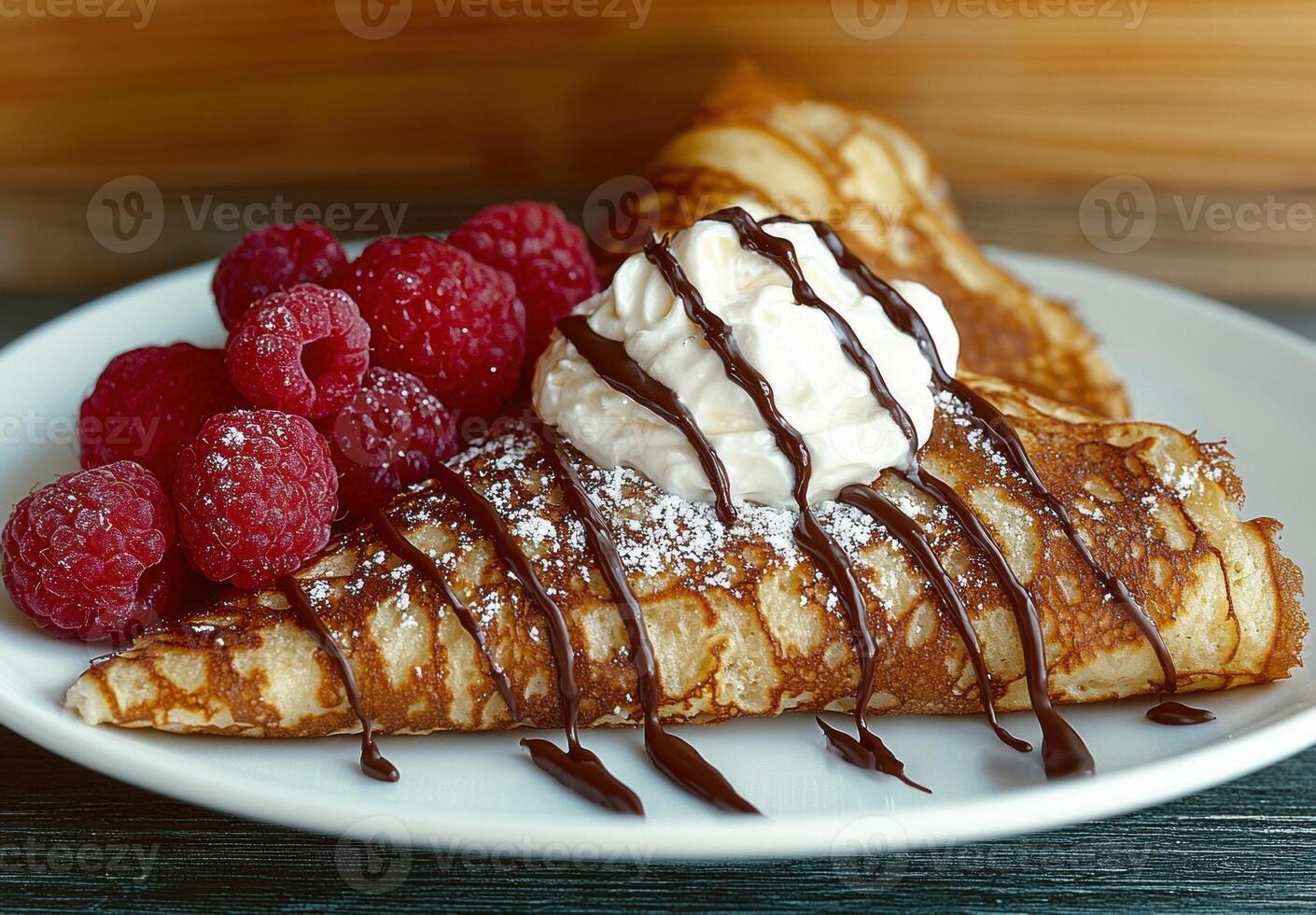 Delicious crepes with whipped cream, chocolate sauce, and raspberries photo