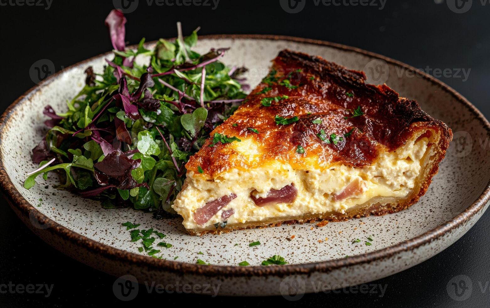A slice of quiche lorraine with a side salad photo