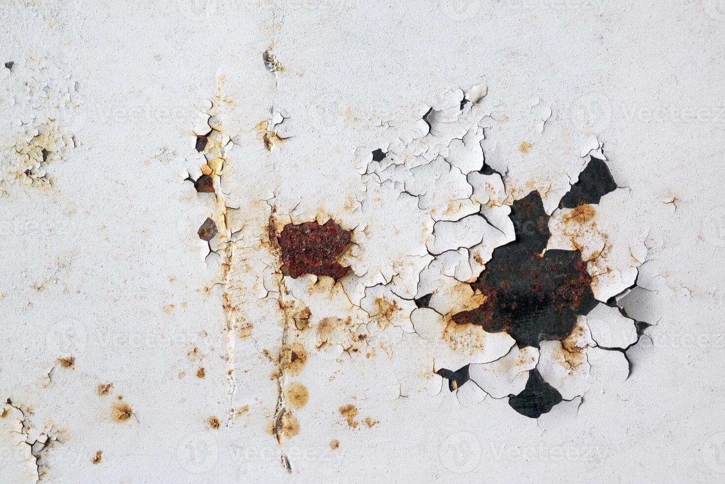 Old rusty metal surface with remnants of white colors photo