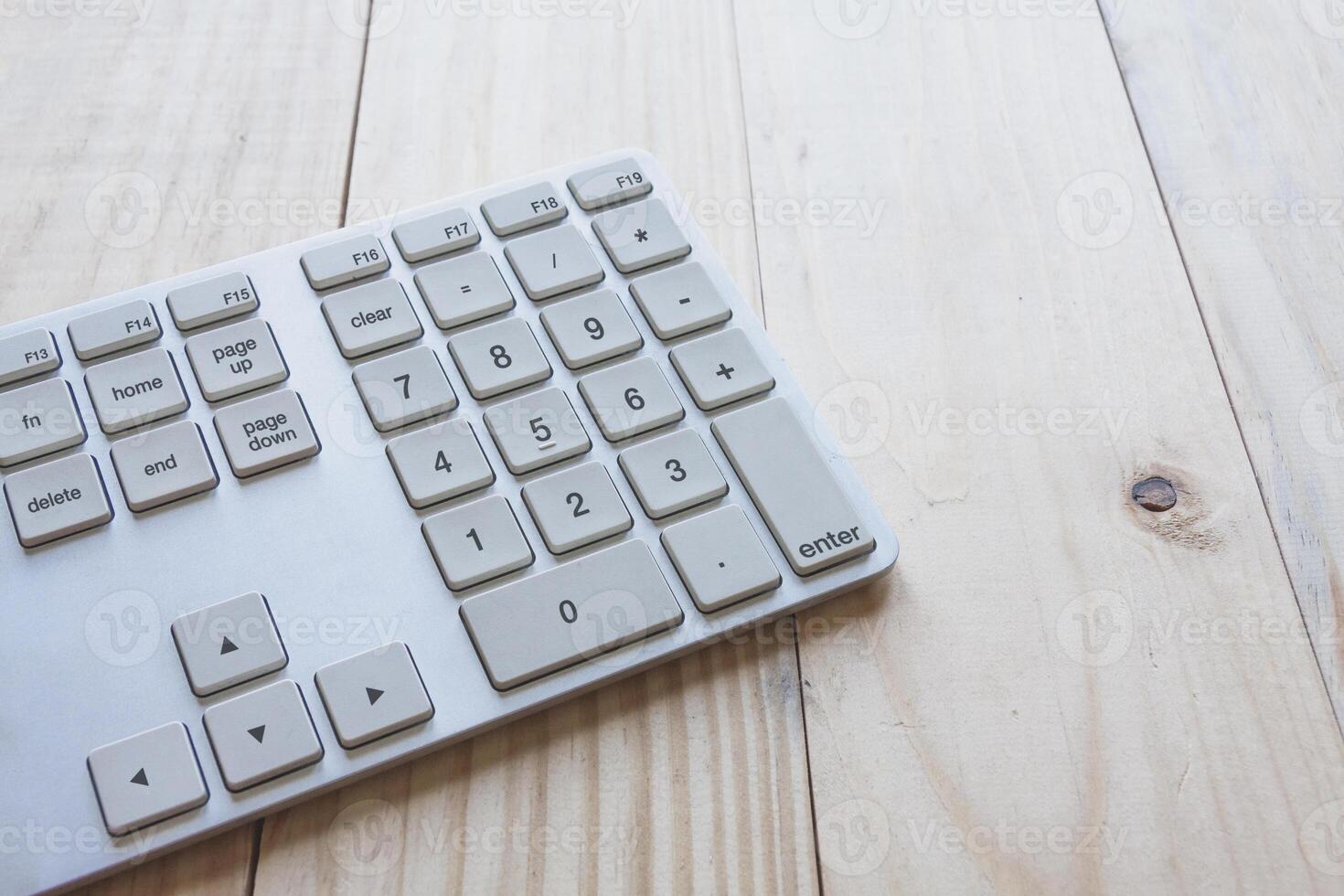 Computer keyboard on top of wooden desk. photo