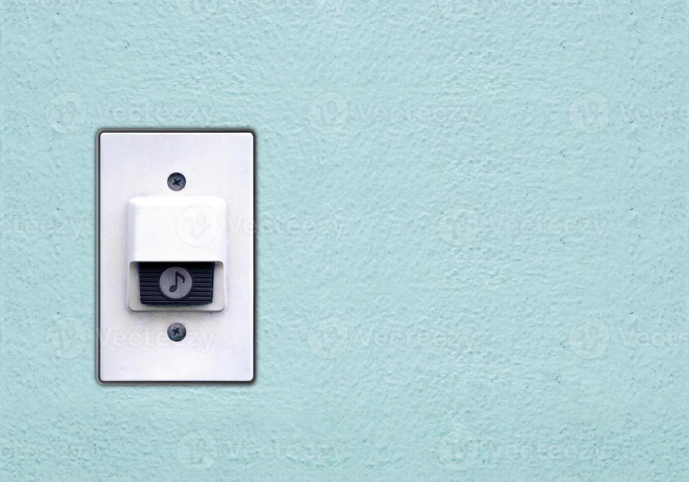 Doorbell or buzzer on mounted on green wall photo