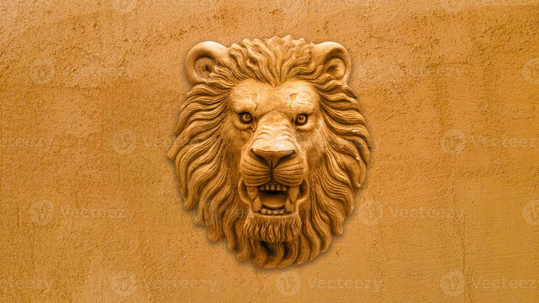 Orange Lion head statue on orange wall photo