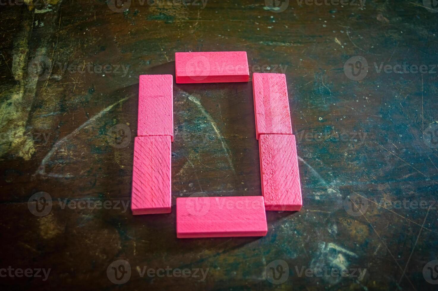 Red wooden blocks arranged in the shape of the number zero on a rustic wooden surface. Perfect for educational, numerical, or creative concepts photo