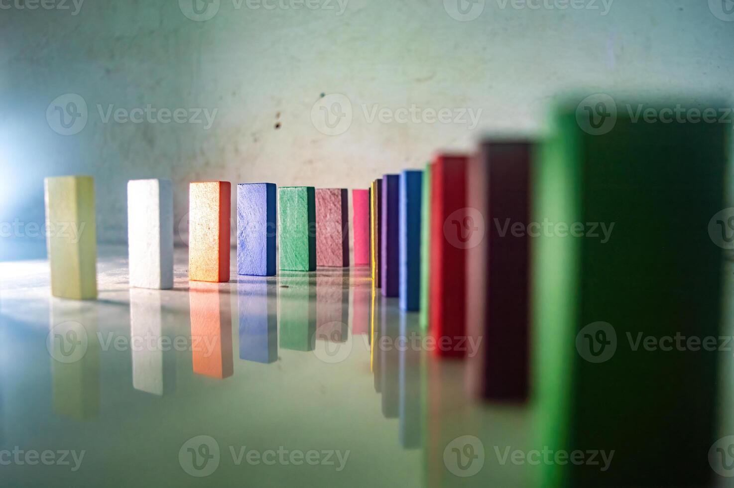 Colorful wooden blocks in a line on a reflective surface, creating a vibrant pattern photo
