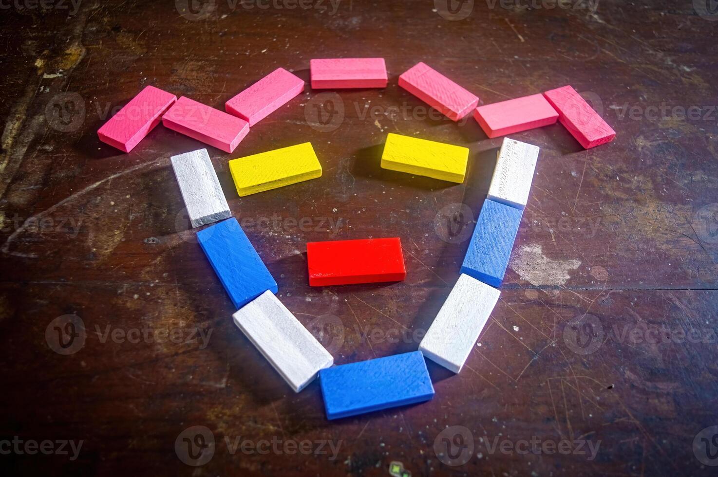 Colorful wooden blocks arranged in a smiley face pattern on a wooden surface, showcasing creativity and playful design photo