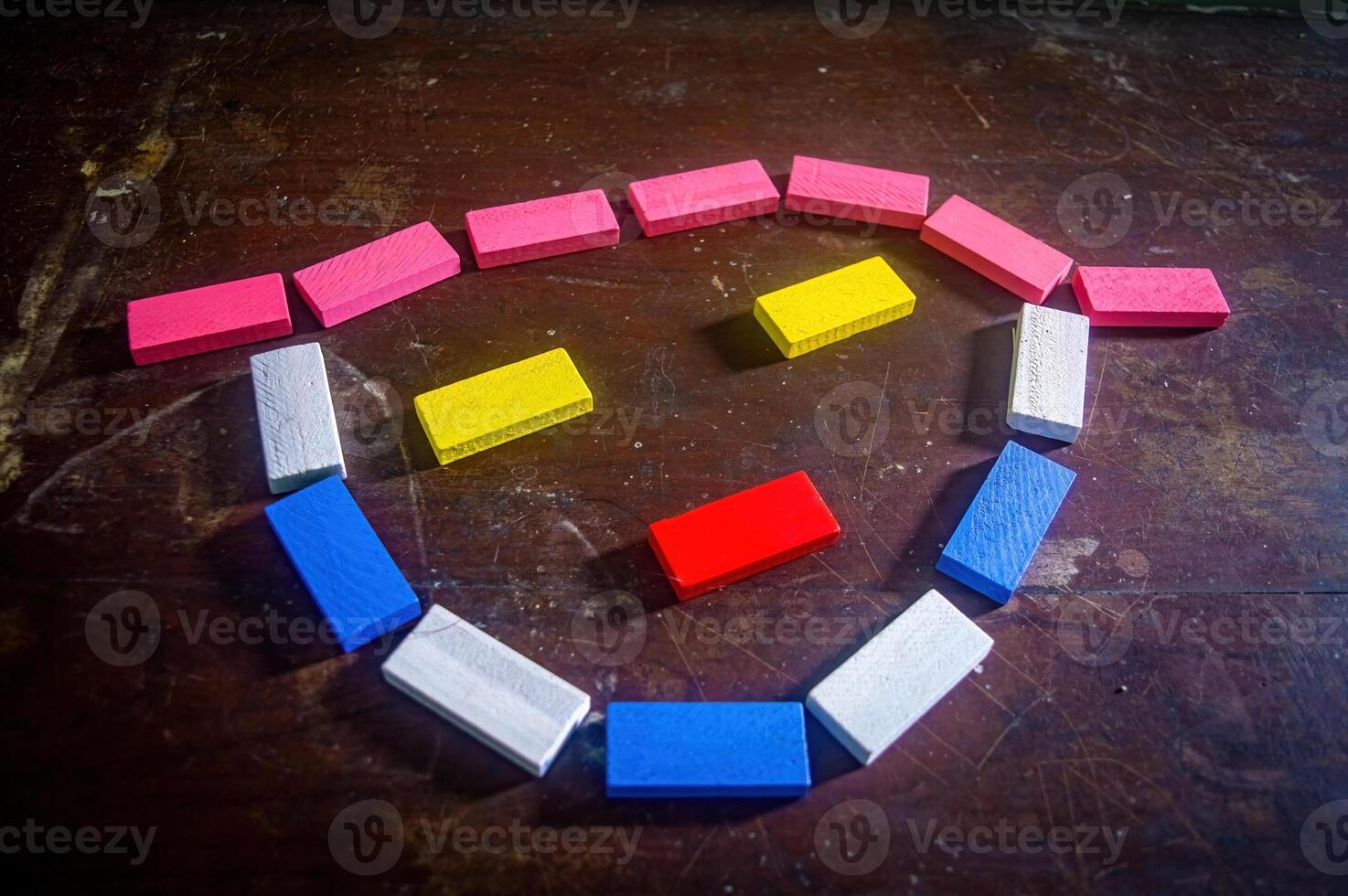 Colorful wooden blocks arranged in a smiley face pattern on a dark wooden surface, creating a playful and cheerful image photo