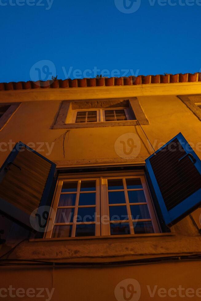 Evening view of a charming building with open shutters in a quaint neighborhood photo