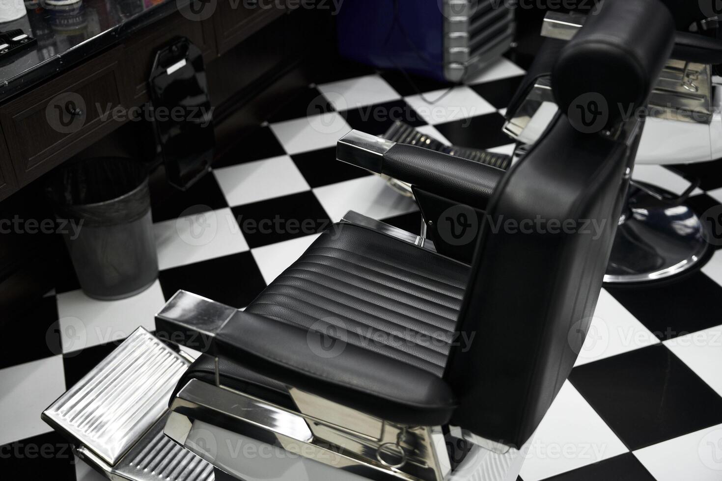 Stylish black salon chair in a modern barbershop with checkered floor design photo