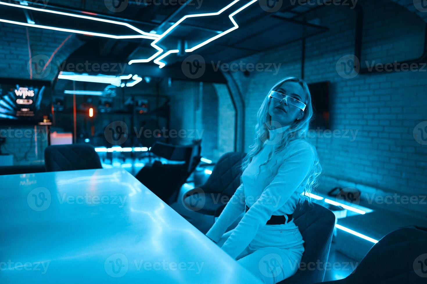 Young woman in neon glasses. Futuristic blonde. photo